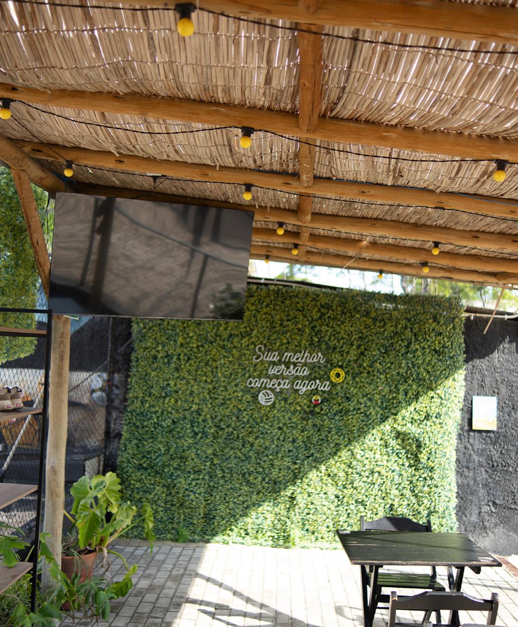 Espaço social com televisão e parede verde da Riplay Morumbi